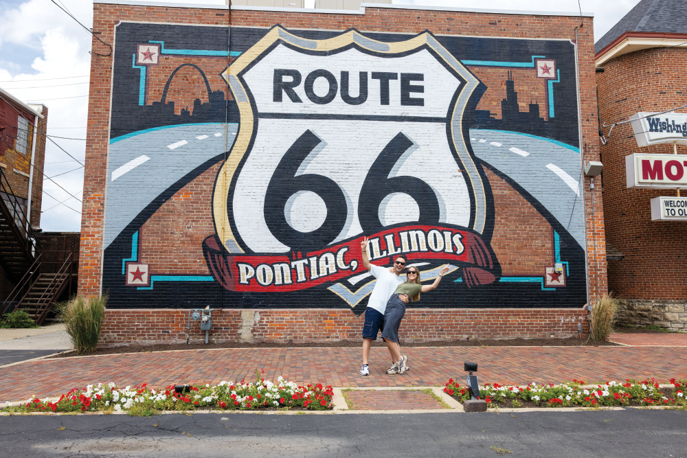 A couple takes a photo in front of the mural on the Route 66 Association Hall of Fame & Museum in Pontiac