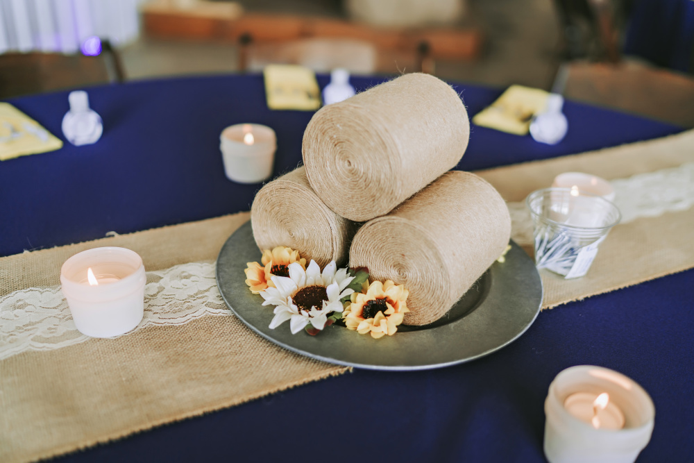 Handcrafted miniature replicas of round bales out of powdered drink containers tightly wrapped in twine for table centers at her wedding