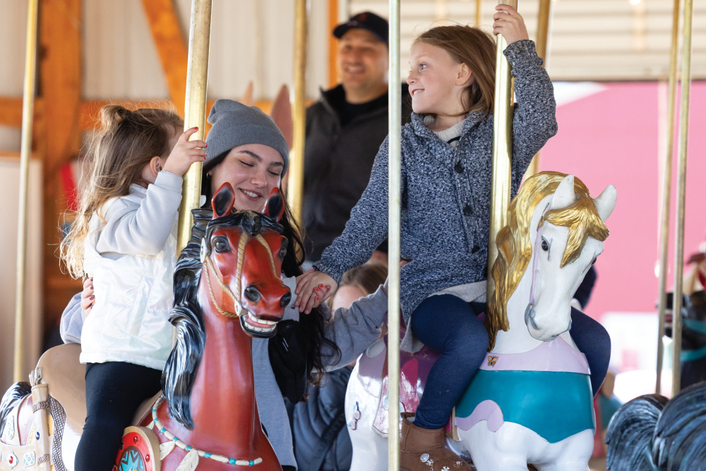 Children ride 100-year-old carousel at Stade’s Farm & Market