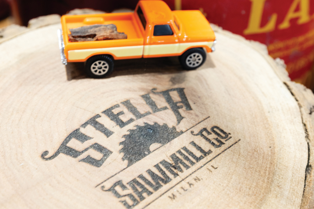 Stella Sawmill stamped on the end of a piece of wood with a toy truck on it