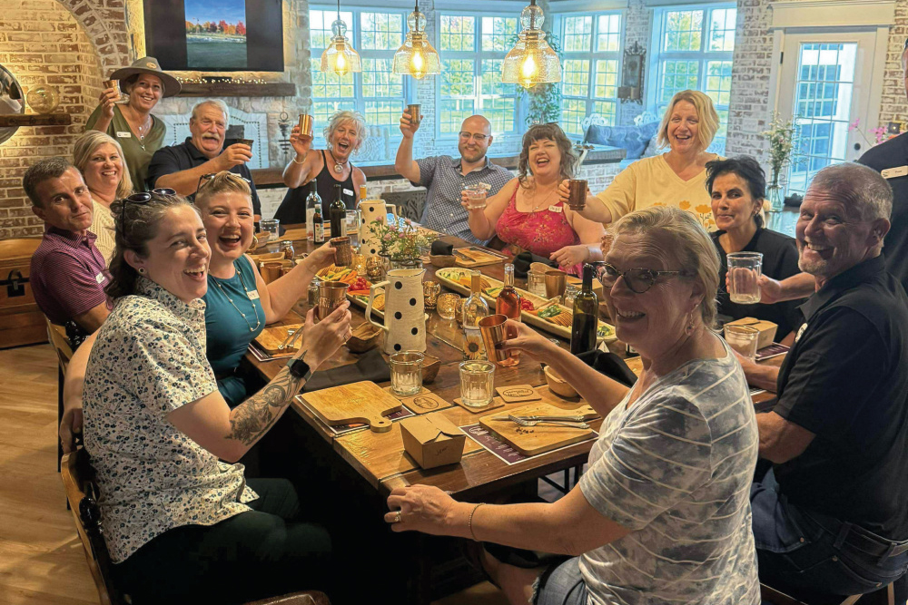 Visitors gathered around a table for one of Pasture Grazed Regenerative Farm's farm-to-table dinners