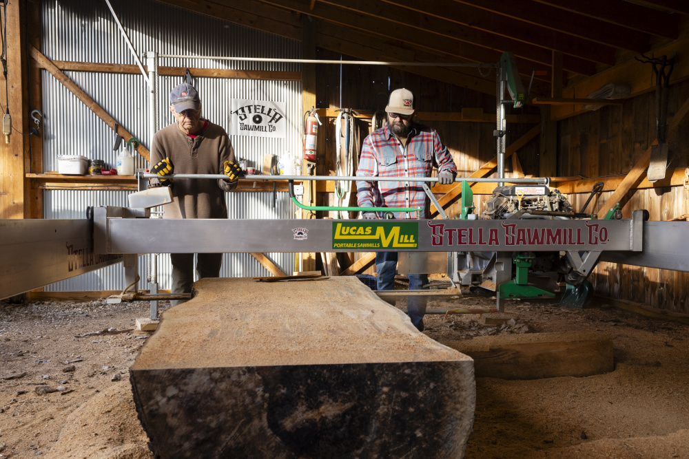 Two man cutting a piece of wood at Stella Sawmill