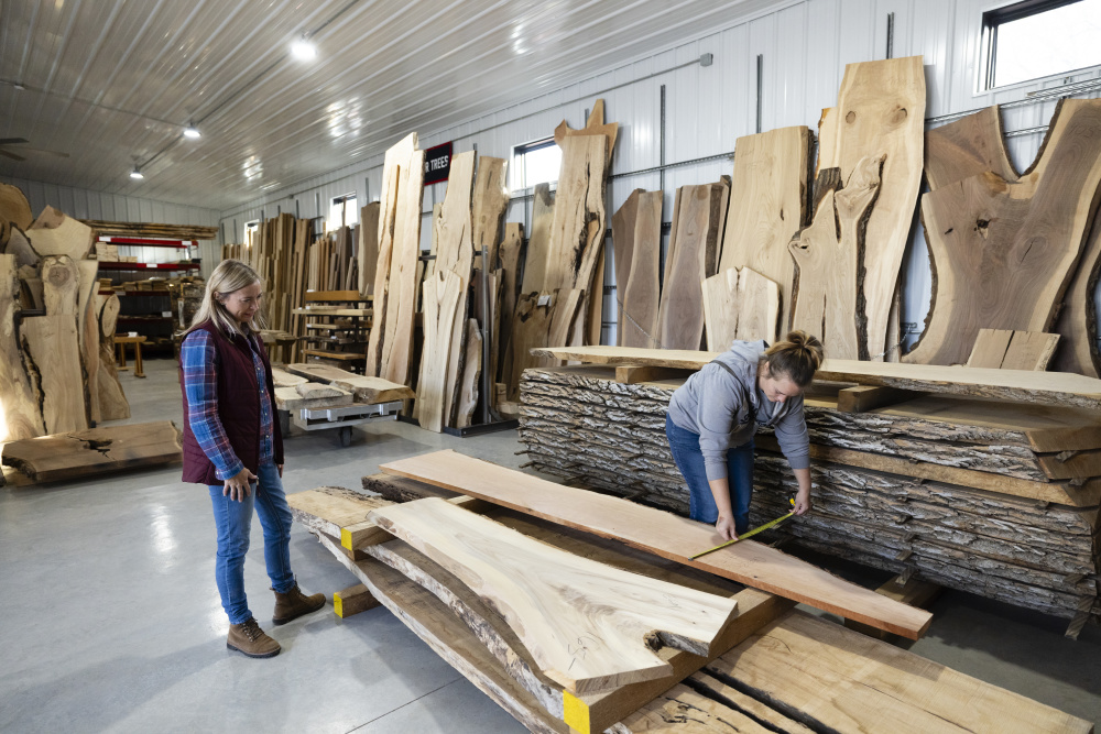 Angie DeVolder helps a customer major a piece of wood at Stella Sawmill